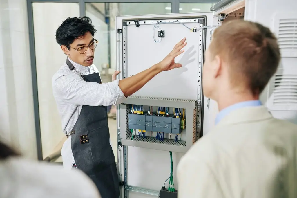 Entrepreneur showing electrical enclosure to inspectors